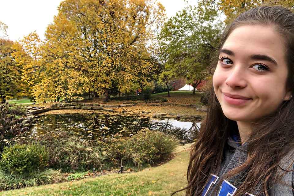 博彩网址大全 student taking a 博彩网址大全 Koi Pond Selfie 